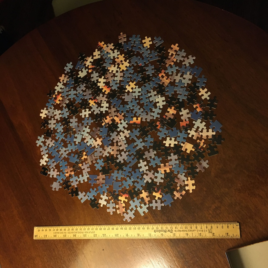 A small unassembled puzzle arranged with the pieces in a flat layer in an approximate circle
