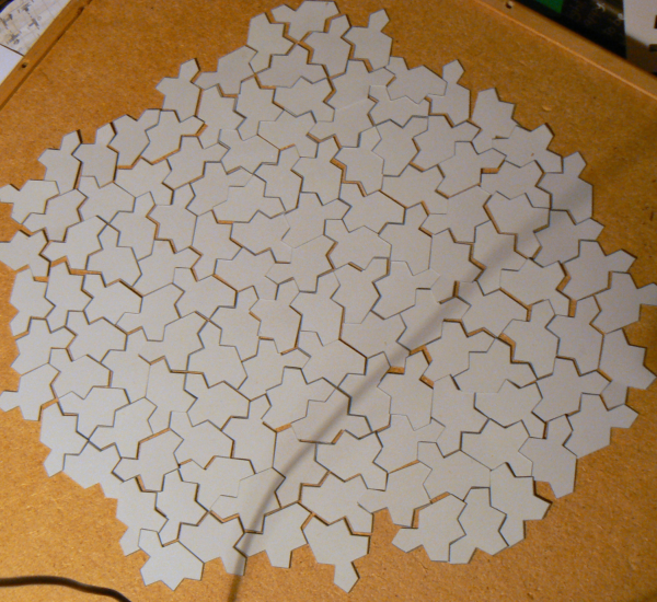 A photograph of a collection of paper cut-outs of Tile(1,1), assembled into a patch by translations and rotations alone.